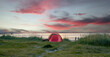 Camping und Zelten am Strand bei wunderschönem Sonnenuntergang mit dem Meer im Hintergrund