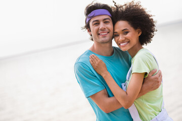 Wall Mural - Photo of charming funny young husband wife cuddling smiling enjoying warm weather outside seaside beach