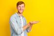 Photo of cheerful positive good looking man trendy outfit toothy smile arm present empty space isolated on yellow color background