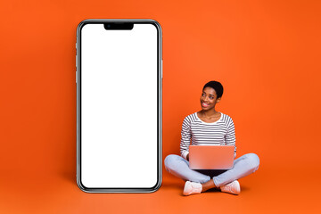 portrait of attractive cheerful girl using laptop copy blank space idea isolated over vibrant orange