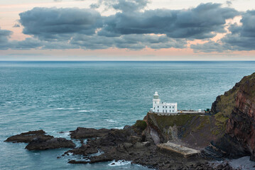 Wall Mural - Lovely sunrise landscape image of Devon coastline in England with stunning golden hour light on the land and sky