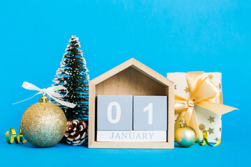 Wall Mural - 1 january. Christmas composition on colored background with a wooden calendar, with a gift box, toys, bauble copy space