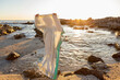 © Tetra Images - South Africa, Gansbaai, De Kelders, Boy (8-9) holding blanket on rocky coastline