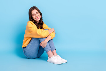 Poster - Full length photo of dreamy shiny lady wear yellow sweater sitting floor empty space isolated blue color background