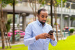 © Ranta Images - Portrait of handsome black man in city using phone