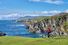 Nice Senior Woman On Mountain Bike, Cycling On The Cliffs Of Achill Island, Carrowgarve, Republik Of Ireland