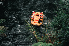 Large Inflatable Boat With Seven People On Board Rowing On The Violent River With A Lot Of Current Among The Vegetation In Okere, New Zealand
