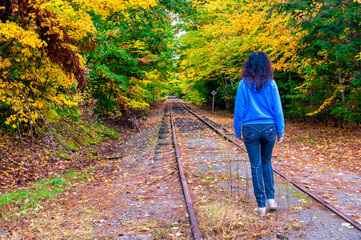 Poster - Woman walking along a trail in fall season