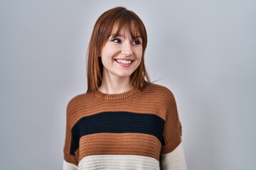 Sticker - Young beautiful woman wearing striped sweater over isolated background looking away to side with smile on face, natural expression. laughing confident.