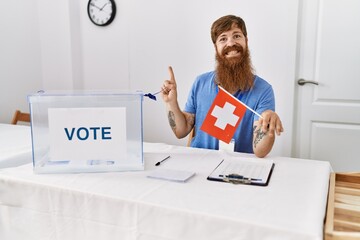 Poster - Caucasian man with long beard at political campaign election holding swiss flag smiling happy pointing with hand and finger to the side