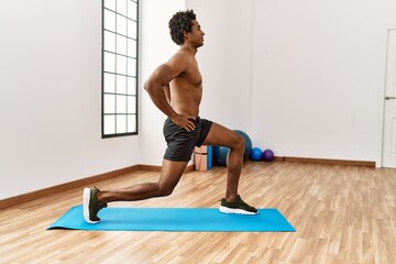 Wall Mural - Young african american man training legs exercise at gym