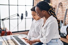 African American Mother And Son Student Learning Play Piano At Music Studio