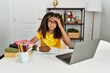 © Krakenimages.com - Young african american girl doing homework at home worried and stressed about a problem with hand on forehead, nervous and anxious for crisis
