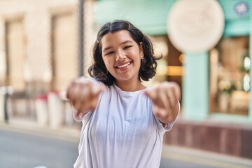 Poster - Young woman smiling confident pointing with fingers at street