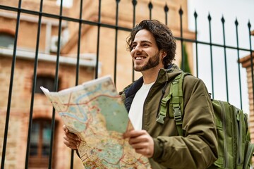 Sticker - Handsome hispanic man looking at travel map at the city