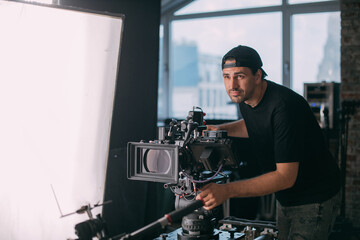 Wall Mural - Director of photography with a camera in his hands on the set.  Filming process indoors, studio