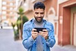 © Krakenimages.com - Young hispanic man watching video on smartphone at street