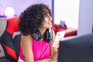 Sticker - Young middle eastern woman streamer using computer and smartphone at gaming room