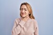 © Krakenimages.com - Hispanic woman standing over blue background touching painful neck, sore throat for flu, clod and infection