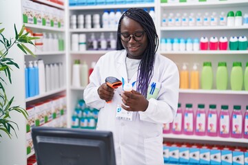 Wall Mural - African american woman pharmacist scanning pills bottle at pharmacy