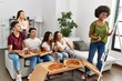 © Krakenimages.com - Group of young friends eating pizza and playing draw game at home.