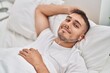 © Krakenimages.com - Young hispanic man listening to music lying on bed at bedroom
