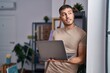 © Krakenimages.com - Young hispanic man artist smiling confident using laptop at art studio