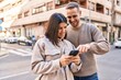 © Krakenimages.com - Man and woman couple smiling confident using smartphone at street