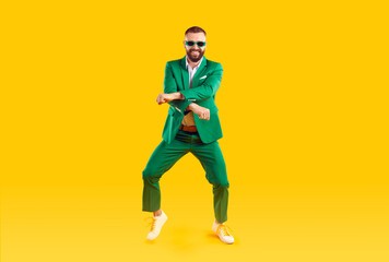 Wall Mural - cheerful and stylish man is having fun dancing in gangnam style at st. patrick's day party. young ma