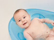 © Klarion - Little baby taking a bath in a blue baby tubh