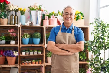 Wall Mural - Middle age grey-haired man florist smiling confident standing with arms crossed gesture at florist