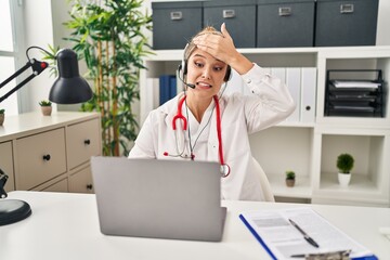 Poster - Young doctor woman wearing doctor uniform working using computer laptop stressed and frustrated with hand on head, surprised and angry face