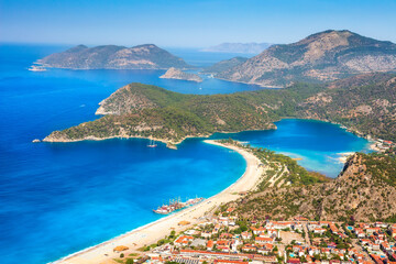 Fototapete - Summer sunny day in blue lagoon surrouded by mountains, Oludeniz (Turkey). Amaizing view from mountain to turistic city Oludeniz. Beautiful view on summer sea with ships.