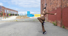 Rollerskate Woman Wearing Checkered Two Piece Body Suit And Skates In An Urban Environment Near A Brick Wall