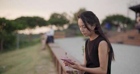 Canvas Print - Woman look at mobile phone in park