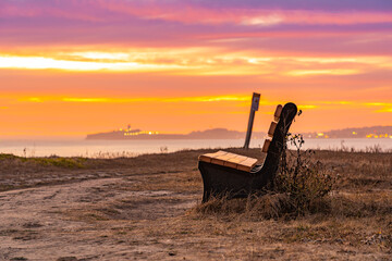Canvas Print - Sunset at the beach and an empty bench 