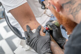 Fototapeta  - Tatoueur en train de tracer un tatouage sur un avant bras