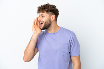 Wall Mural - Young handsome caucasian man isolated on white background shouting with mouth wide open to the side