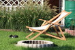 a garden sun lounger, next to it lie female shoes on a background of green ornamental grasses.
leżak ogrodowy, obok leżą buty damskie na tle zielonych traw ozdobnych.