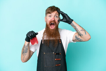 Wall Mural - Butcher man wearing an apron and serving fresh cut meat isolated on blue background with surprise expression