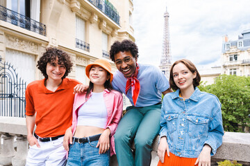 Multiethnic group of young happy teens friends bonding and having fun while visiting Eiffel Tower area in Paris, France