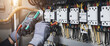 Leinwandbild Motiv Electricity and electrical maintenance service, Engineer hand holding AC multimeter checking electric current voltage at circuit breaker terminal and cable wiring main power distribution board.