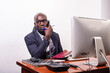 © vystekimages - young business man talking on mobile phone in office.