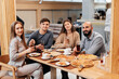 © Andrii - A cheerful group of friends is eating delicious pizza in a restaurant. Friends are sitting in a restaurant and having fun.