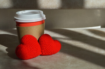 a glass for hot drinks, tea and coffee. background for the design. two red hearts, valentine's day, love.