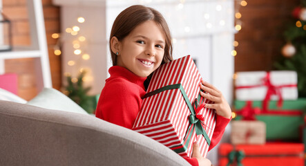 Poster - Cute smiling little girl with Christmas gift at home