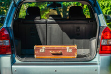 Old Shabby Leather Suitcase In The Trunk Of A Car