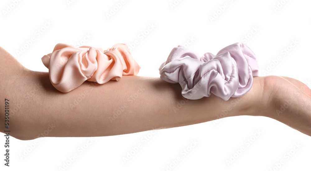 Silk scrunchies on female hand against white background, closeup