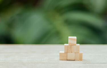 wooden blank cube blocks on desk with copy space. wooden cube blocks arranging on table with nature background.