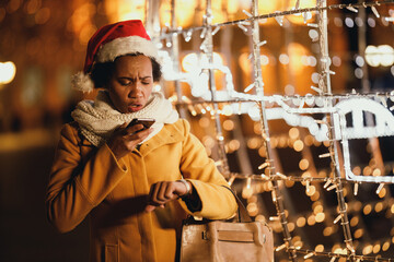 Wall Mural - Black Woman Using Smartphone In The City At Christmas Time